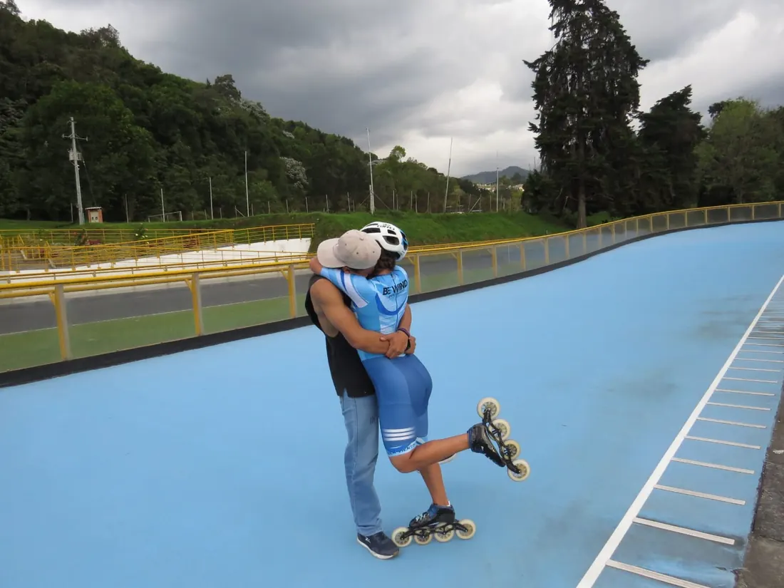 Ella en patines lo abraza en la pista