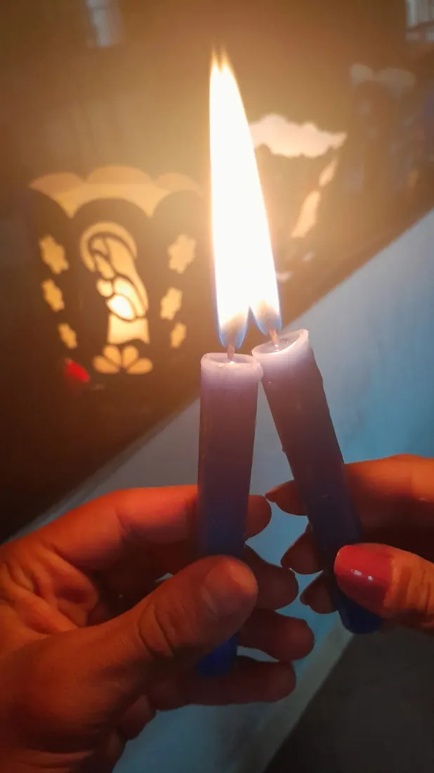 Dos velas azules juntas, sus llamas se vuelven una